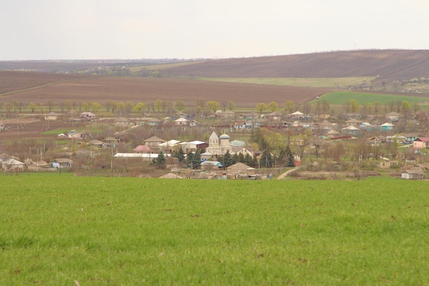 un gran campo verde con una casa blanca en el medio