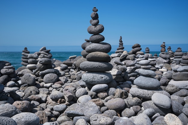 Gran cantidad de piedras zen apiladas en la playa, Puerto de la Cruz, Tenerife, España.