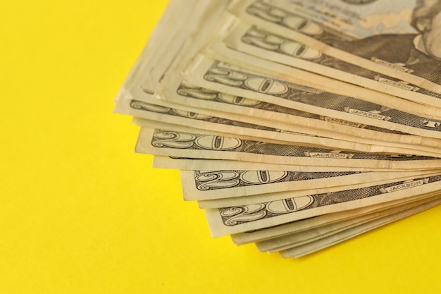 Gran cantidad de viejos billetes de veinte dólares sobre fondo amarillo Ganancias de dinero día de pago o período de pago de impuestos