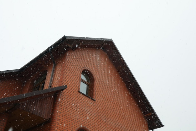 Gran casa de ladrillos en un hermoso día de nieve