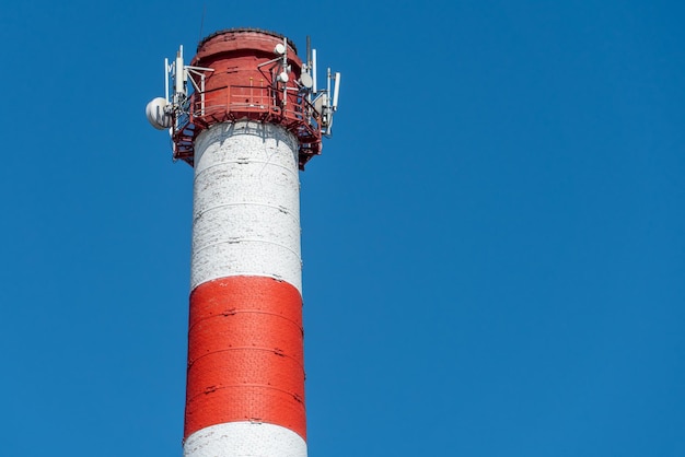 Una gran chimenea industrial contra un cielo azul Tubería roja y blanca en empresas comerciales o centrales eléctricas