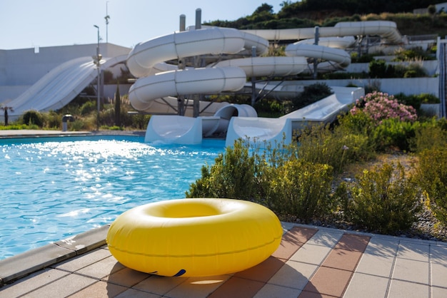 Un gran círculo inflable amarillo se encuentra al borde de la piscina en el parque acuático