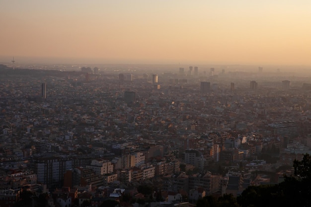 Gran ciudad durante la puesta de sol Siluetas de edificios desde arriba