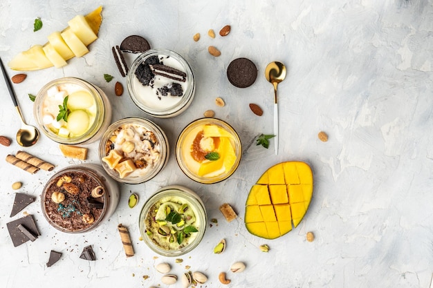 Gran colección de deliciosos helados con helado de pistacho, chocolate, caramelo, melón, mango, galletas de sándwich con trocitos de chocolate y vaina de vainilla aromática en blanco