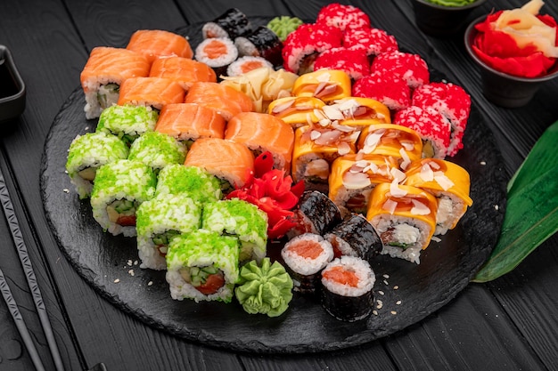 Gran conjunto de comida asiática Sushi y rollos sobre un fondo oscuro