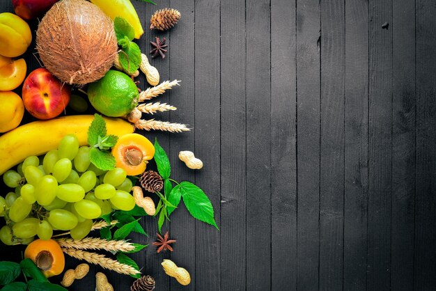 Gran conjunto de fruta fresca en una mesa de madera negra Espacio libre para su texto Vista superior