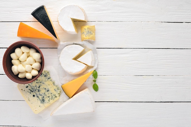 Un gran conjunto de quesos Mozzarella queso azul queso brie maasdam Vista superior Sobre un fondo blanco de madera Espacio libre para su texto