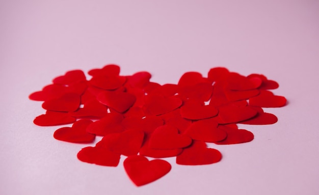 Gran corazón hecho de pequeños corazones de papel sobre fondo rosa Símbolo de amor del Día de San Valentín