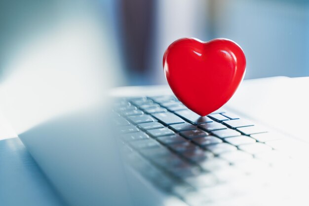Gran corazón rojo en el teclado de la computadora portátil Concepto de vacaciones del día de San Valentín Amor en línea Comunicación remota en las redes sociales de Internet Llamadas de citas virtuales y tecnología Cuarentena coronavirus covid19