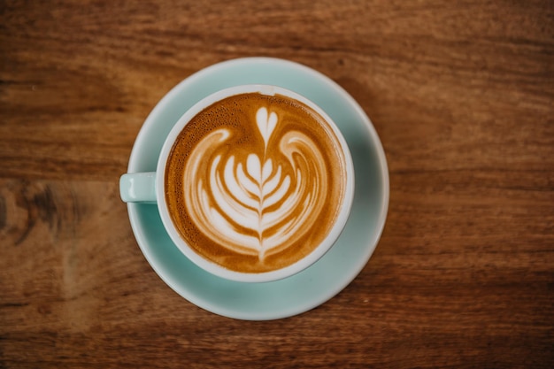 Gran diseño de café latte art y mesa de madera.