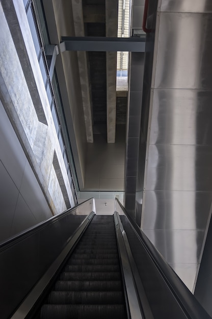 Foto la gran escalera vacía está subiendo hasta el piso de la plataforma en la estación de tren de metro, probando la funcionalidad antes del servicio real, vista frontal para el fondo.