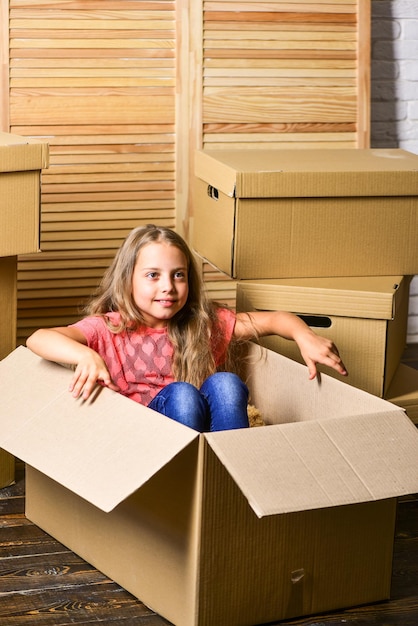 Gran espacio de almacenamiento Reubicar a la familia estresante para los niños Niño niña reubicando cajas de fondo Concepto de reubicación Servicio de entrega Paquete de caja y almacenamiento Niño pequeño prepararse para la reubicación