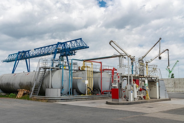 Foto gran estación de servicio industrial con grandes tanques de combustible y puente grúa