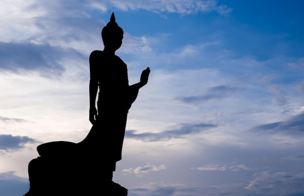 Gran estatua de bronce de Buda caminando en la provincia budista de Phutthamonthon Tailandia en el crepúsculo