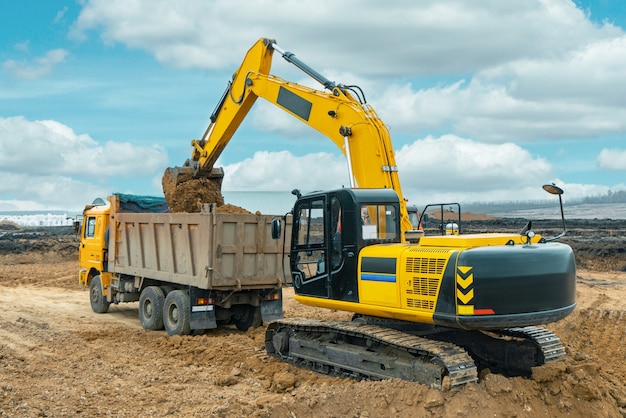 Una gran excavadora de construcción de color amarillo en el sitio de construcción en una cantera para canteras
