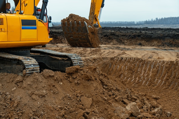 Una gran excavadora de construcción de color amarillo en el sitio de construcción en una cantera para la extracción. Imagen industrial