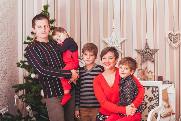 Gran familia alegre sentado en el interior de la casa decorada de Navidad