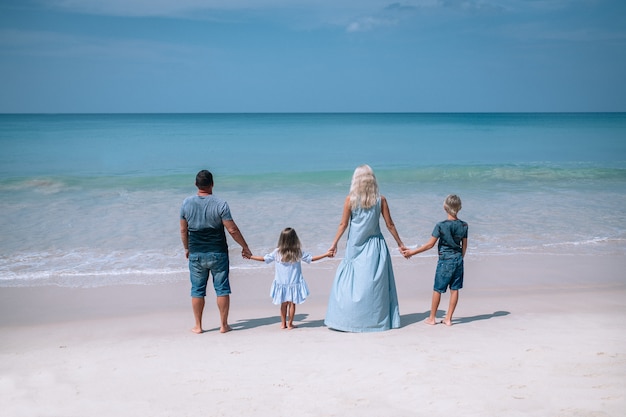 Gran familia cogidos de la mano y de pie cerca del mar