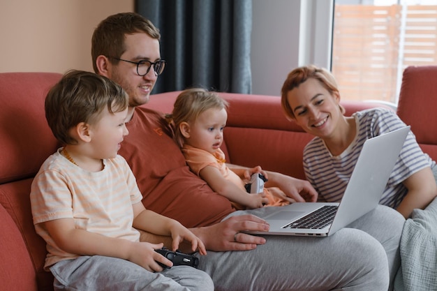 Gran familia feliz con niños viendo películas jugando juegos en la computadora portátil