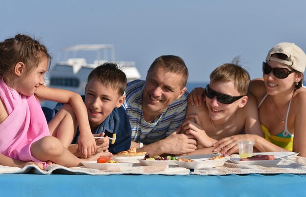 Foto gran familia feliz en un picnic en la playa