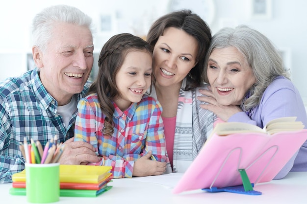 Gran familia con linda niña haciendo la tarea juntos