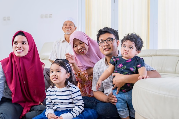 Gran familia musulmana viendo la televisión felizmente