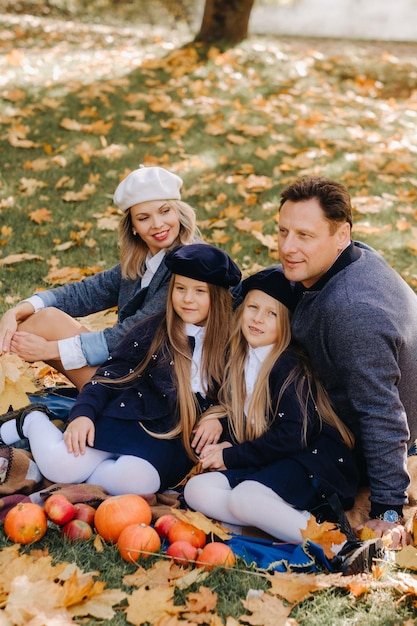 Una gran familia en un picnic en otoño en un parque natural Gente feliz en el parque de otoño