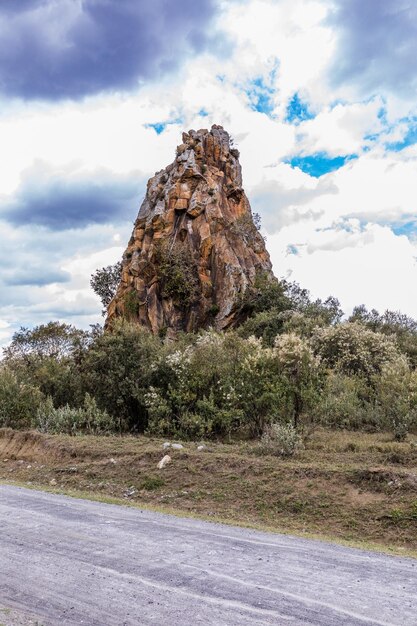 Foto una gran formación rocosa está en el fondo de un cielo nublado