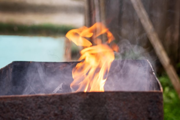 Gran fuego naranja en la parrilla de cerca