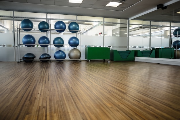 Gran gimnasio vacío con estante de bolas de ejercicio