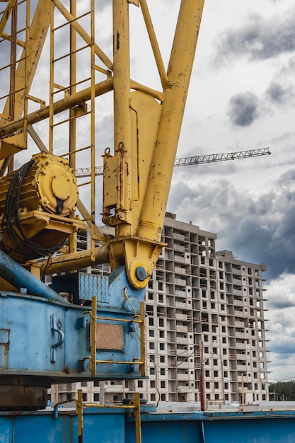 Una gran grúa torre en un sitio de construcción en el contexto de una casa monolítica moderna Construcción de viviendas modernas ingeniería industrial Construcción de viviendas hipotecarias