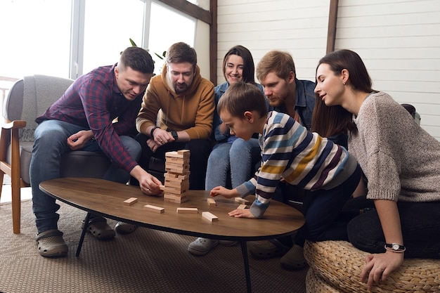 Un gran grupo de amigos juega a juegos de mesa, una alegre compañía en casa. Foto de alta calidad