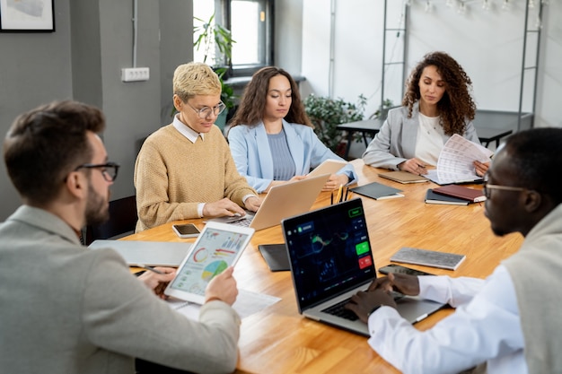 Gran grupo de financista trabajando individualmente por mesa en la oficina