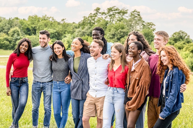 Un gran grupo de jóvenes estudiantes universitarios de la Generación Z se divierten al aire libre en un parque de la ciudad