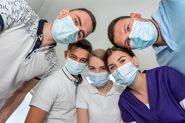 Foto un gran grupo de médicos y enfermeras motivados parados en círculo y bromeando entre ellos