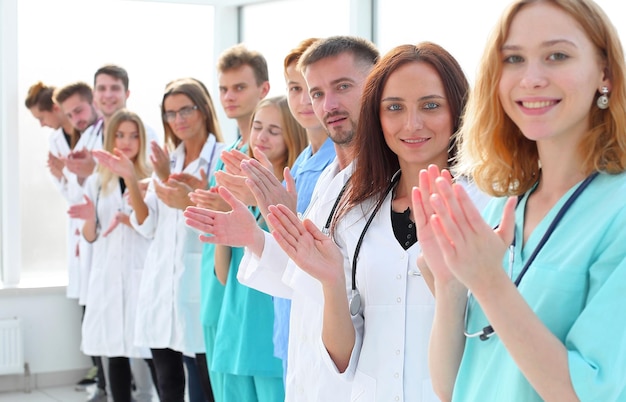 Gran grupo de médicos de pie en fila y aplaudiendo