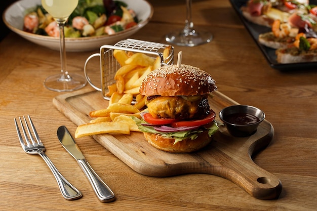 Gran hamburguesa con queso y papas fritas aisladas sobre fondo blanco