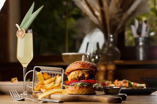 Foto gran hamburguesa con queso y papas fritas aisladas sobre fondo blanco