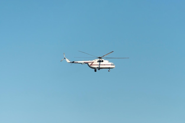 Un gran helicóptero civil blanco sobre un fondo de cielo azul Un avión tripulado en el cielo Transporte de pasajeros y carga por aire