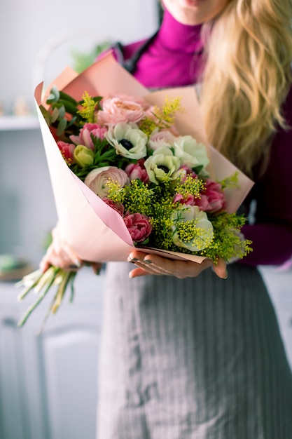 Gran hermoso ramo de flores mixtas en mano de mujer. Concepto de tienda de flores