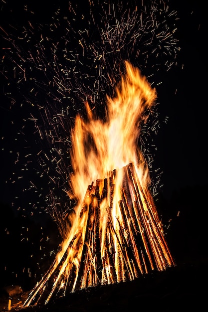 Gran hoguera por la noche. Llamas de fuego sobre fondo negro