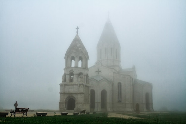 Foto gran iglesia pedregosa rodeada de vegetación en shushi artsakh