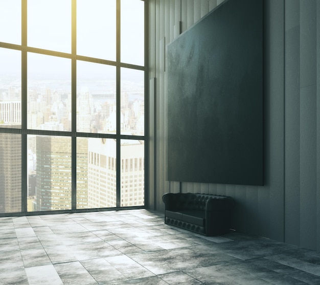 Gran imagen negra en blanco sobre un sofá de cuero en un loft vacío con grandes ventanales y suelo de hormigón