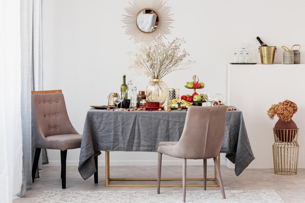 Gran jarrón de vidrio elegante con flores secas en la mesa de comedor para la fiesta de cumpleaños