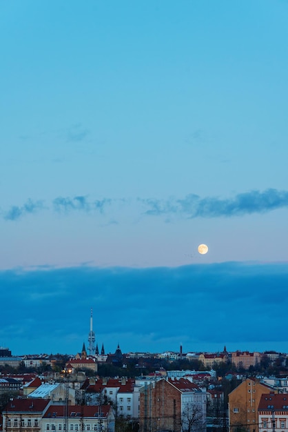 Gran luna sobre la ciudad con cielo azul y nubes