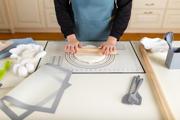 Una gran mesa de trabajo de cocina en la que el chef extiende la masa de trigo para hornear