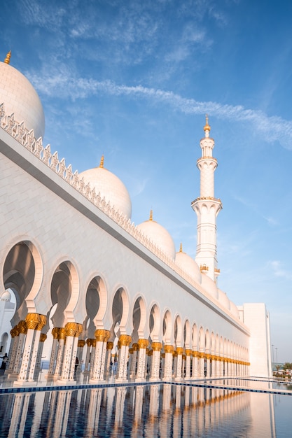 Gran Mezquita de Abu Dhabi por la noche durante la puesta de sol. Panorama del exterior de Sheikh Zayed Mosquein en los Emiratos Árabes Unidos.