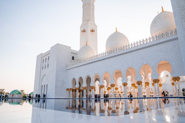 Gran Mezquita de Abu Dhabi por la noche durante la puesta de sol. Panorama del exterior de Sheikh Zayed Mosquein en los Emiratos Árabes Unidos.