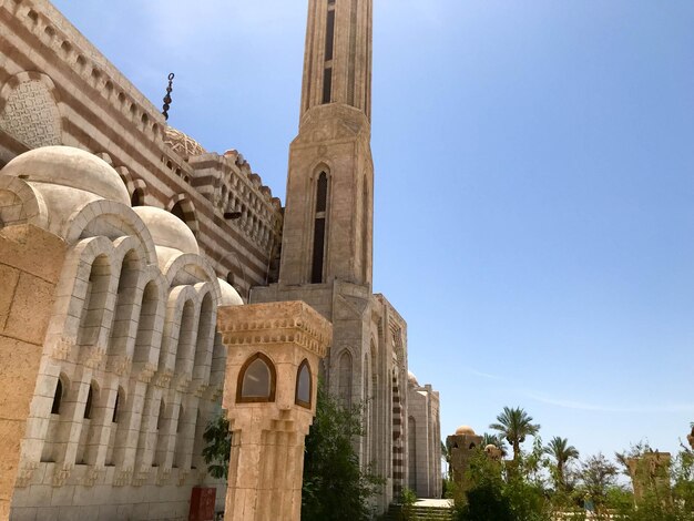 Una gran mezquita musulmana árabe islámica de piedra beige un templo para rezar a un dios con una torre alta