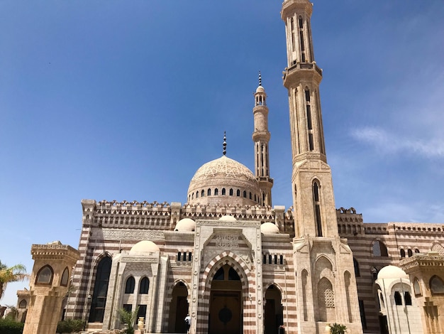 Una gran mezquita musulmana árabe islámica de piedra beige un templo para rezar a un dios con una torre alta